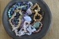 A pottery bowl with healing gem stones and crystals on a wooden background