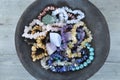 A pottery bowl with healing gem stones and crystals on a wooden background