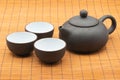 Pottery Chinese teapot and teacup on bamboo mat Royalty Free Stock Photo