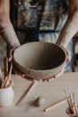 Pottery, clay, ceramics art concept - closeup on hands of young master with the large plate from fireclay Royalty Free Stock Photo