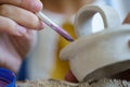 Pottery creation: creative process in potter studio with female ceramist painting clay kitchenware Royalty Free Stock Photo