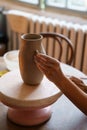 Pottery hobby: hands of professional ceramist work on potter vase in studio create jug of raw clay Royalty Free Stock Photo