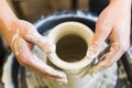 Pottery making. Smeared in clay hands of man on potter`s wheel. Royalty Free Stock Photo