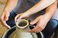 Pottery making. Smeared in clay hands of man and woman on potter`s wheel Royalty Free Stock Photo