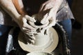 Pottery making. Smeared in clay hands of man and woman on potter`s wheel Royalty Free Stock Photo