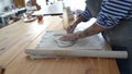 Pottery master cutting trimming clay on wooden table, ceramist using mold to create ceramic plate