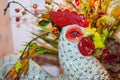 Pottery rooster head in front of flower arrangement - selective focus