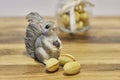 Pottery squirrel with acorn and three walnut shaped butter cookies on a wooden surface.