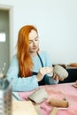 Pottery studio, artisan business,red hair female potter holding ceramic bowl ready for firing in a kiln