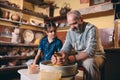 Pottery workshop. Grandpa teaches granddaughter pottery. Clay modeling