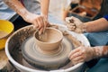 Pottery workshop. Hands of adult and child making pottery, working with wet clay closeup. Process of making bowl from clay on Royalty Free Stock Photo