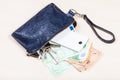 Pouch with phone, keys and many euros on table Royalty Free Stock Photo