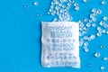 Pouch with Silica gel unfolded on blue background Royalty Free Stock Photo