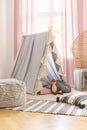 Pouf on patterned rug near tent with fox toy in girl`s room with pink drapes and pillows. Real photo Royalty Free Stock Photo