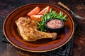 Poultry dish - roasted chicken legs with vegatables salad. Dark background. Top view