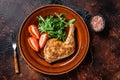 Poultry dish - roasted chicken legs with vegatables salad. Dark background. Top view