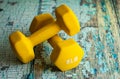 8 pound yellow weights on a rustic wooden table Royalty Free Stock Photo