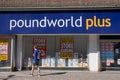 Poundworld plus shop sign with man walking past