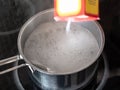 Pour baking soda into pot with boiling water Royalty Free Stock Photo