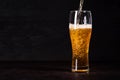 Pour beer in beer glass on dark wooden background. October fest background Royalty Free Stock Photo