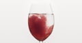 Pour blueberry juice into water in wine glass