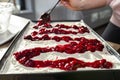 Pour the cherry sauce over the cheesecake with a teaspoon, finishing the preparation of the Japanese cake.