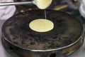 Pour the dough from a ladle of ladles on a hot hot pancake maker. the process of making pancakes, traditional Thai fast food for Royalty Free Stock Photo