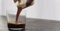 pour espresso in tumbler glass on black aok table