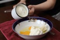 Pour flour from a mug into a plate with eggs, sugar, cottage cheese and other ingredients, prepare pizza at home, Easter, cupcake