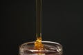 Pour honey into glass jar closeup