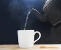 Pour hot water with a white cup  on black. Royalty Free Stock Photo