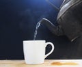 Pour hot water with a white cup  on black. Royalty Free Stock Photo