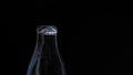 Pour milk into the bottle in slow motion, the milk in a glass bottle placed on the sack. Concept of: Fresh, Pour, Black Background Royalty Free Stock Photo