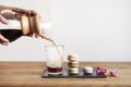 Pour over coffee brewing method Chemex, woman hands hold a glass bowl, still life with brownie cookies on wooden table. Royalty Free Stock Photo