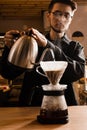 Pour over filter coffee alternative brewing method. Barista is pouring hot water over roasted and ground coffee beans Royalty Free Stock Photo