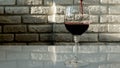 Pour red wine glass against a brick wall background,alcoholic drink grape red,close-up. Royalty Free Stock Photo