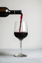 Pour red wine on white background. Generative ai Royalty Free Stock Photo