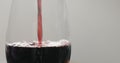 Pour red wine into wine glass from bottle closeup Royalty Free Stock Photo