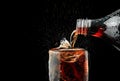 Pour soft drink in glass with ice splash on dark background. Royalty Free Stock Photo
