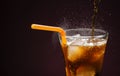 Pour sparkling water in a cola glass with ice cubes. on a dark black background Royalty Free Stock Photo