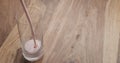 Pour strawberry yogurt into glass on wood table