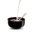 Pour a stream of milk on the chocolate flakes balls in a black bowl Royalty Free Stock Photo