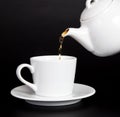 Pour tea from the teapot into the cup Royalty Free Stock Photo