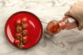 Pour tomato juice into a glass. Hand pours tomato juice from bottle into glass, marble table top background. Banner copy space Royalty Free Stock Photo