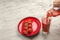 Pour tomato juice into a glass. Hand pours tomato juice from bottle into glass, marble table top background. Banner copy Royalty Free Stock Photo