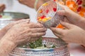 Pour water on the hands of revered elders and gives blessing in