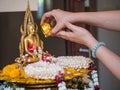 Pour water onto a Buddha statue