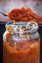Pouring ajvar into the jar with spoon Royalty Free Stock Photo