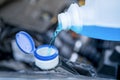 Pouring antifreeze. Filling a windshield washer tank with an antifreeze in winter cold weather. Royalty Free Stock Photo