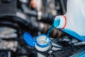 Pouring antifreeze. Filling a windshield washer tank with an antifreeze in winter cold weather. Royalty Free Stock Photo